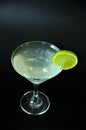 Glass of Daiquiri cocktail with ice and a slice of lime on the edge on a black background Royalty Free Stock Photo