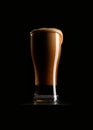 A glass of dark beer on a black background. Royalty Free Stock Photo