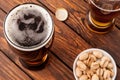 glass of dark cold frothy beer, nuts, bottle cap, old wooden tab Royalty Free Stock Photo