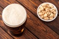 glass of dark cold frothy beer, nuts old wooden table Royalty Free Stock Photo