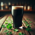 Glass of dark stout sits on wooden table, with sprinkling of shamrocks