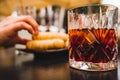 Glass of dark vermouth drink with slice of orange on a bar table outdoors, a popular aperitif, during a summer day with snacks and Royalty Free Stock Photo