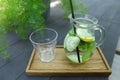 Glass decanter and glass faceted cup stands on plank on table in Royalty Free Stock Photo