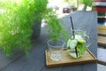 Glass decanter and glass faceted cup stands on plank on table in Royalty Free Stock Photo