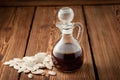 Glass decanter with pumpkin oil and a bunch of pumpkin seeds on a wooden background Royalty Free Stock Photo