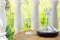 Glass Decanter with Red Wine on Rattan Wicker Table in Garden Terrace of Villa or Mansion. Authentic Lifestyle Image Royalty Free Stock Photo
