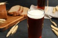 Glass of kvass, bread and spikes on black table Royalty Free Stock Photo