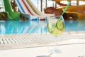 Glass of mojito near swimming pool, space for text. Refreshing drink Royalty Free Stock Photo