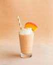 A glass of delicious peach smoothie isolated on peach fuzz pantone color with whipped cream, generative ai