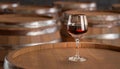 Glass with delicious red wine on wooden barrel. Wine Barrels in Cellar. Red Wine with Old Barrel Wooden Background Royalty Free Stock Photo