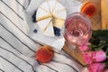 Glass of delicious rose wine, flowers and food on white picnic blanket Royalty Free Stock Photo