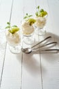 Glass of dessert with whipped cream with a fresh mint leaf and kiwi fruit on white table. Royalty Free Stock Photo