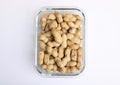 Glass dish of peanuts or monkey nuts against plain white background Royalty Free Stock Photo