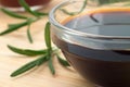 Glass dish with soy sauce and rosemary sprigs