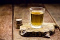 Glass of distilled alcoholic beverage on wooden background with copy space for text. Call for rum or cachaÃÂ§a