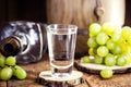Glass of distilled drink based on fermented grapes of high alcohol content, on rustic wooden background