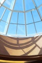 Glass dome constructions shadows in shopping mall in sunny day. Vertical photo