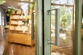 Glass door with handle in to coffee shop or shop. Door handle is a mechanism used to open or close door, Aluminum door