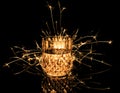 Glass, drink with fizzy sparkler isolated on black background.