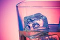 Glass of drink with ice on disco violet light Royalty Free Stock Photo