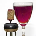 A glass of dry red wine and a wine stopper on a corkscrew close-up