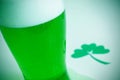 Glass with dyed green beer and three-leaved shamrock, for saint