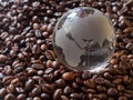Glass earth globe Africa and Asia in center closeup among coffee beans background Royalty Free Stock Photo