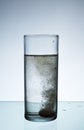 Glass with efervescent tablet in water. Royalty Free Stock Photo