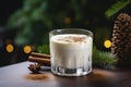 Glass of eggnog covered with layer of whipped cream. Traditional Christmas drink is decorated with cinnamon sticks