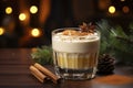 Glass of eggnog covered with layer of whipped cream. Traditional Christmas drink is decorated with cinnamon sticks