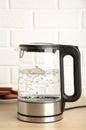 Glass electric kettle with boiling water and chocolate chip cookie on white background Royalty Free Stock Photo