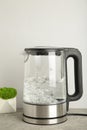 Glass electric kettle with boiling water on grey background Royalty Free Stock Photo