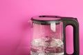 Glass electric kettle with boiling water on pink background Royalty Free Stock Photo