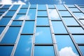 glass facade of a modern office building against a blue sky