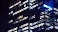 The glass facade of a modern skyscraper at night. Modern glass office in city. Royalty Free Stock Photo