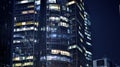 The glass facade of a modern skyscraper at night. Modern glass office in city. Royalty Free Stock Photo