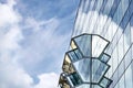 The glass facade of the office building with protruding windows against a blue sky with white clouds, modern architecture Royalty Free Stock Photo