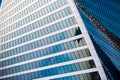 Glass facade of office building on a sunny day with reflection of skyscrapers. Royalty Free Stock Photo