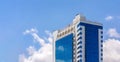 Glass facade of a tall building in the background of the cloudy sky