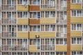 A glass facade with windows of a brick apartment building with loggias and balconies. Condominium with air conditioning