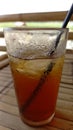 a glass filled with cold sweet iced tea on a bamboo table Royalty Free Stock Photo