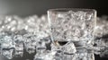 A glass filled with ice cubes, surrounded by scattered ice on a reflective surface Royalty Free Stock Photo