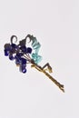 A glass flower twig, three blue flowers with golden stamens