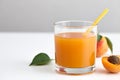 Glass of fresh apricot juice with yellow straw Royalty Free Stock Photo