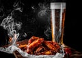 Glass of fresh beer and fried chicken wings on wooden table Royalty Free Stock Photo