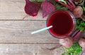 Glass of fresh beet juice, downward scene over wood