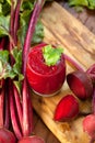 Glass of fresh beetroot juice with bets on wooden table. Royalty Free Stock Photo