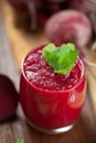 Glass of fresh beetroot juice with bets on wooden table. Royalty Free Stock Photo