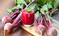 Glass of fresh beetroot juice with bets on wooden table. Royalty Free Stock Photo