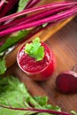 Glass of fresh beetroot juice with bets on wooden table. Royalty Free Stock Photo